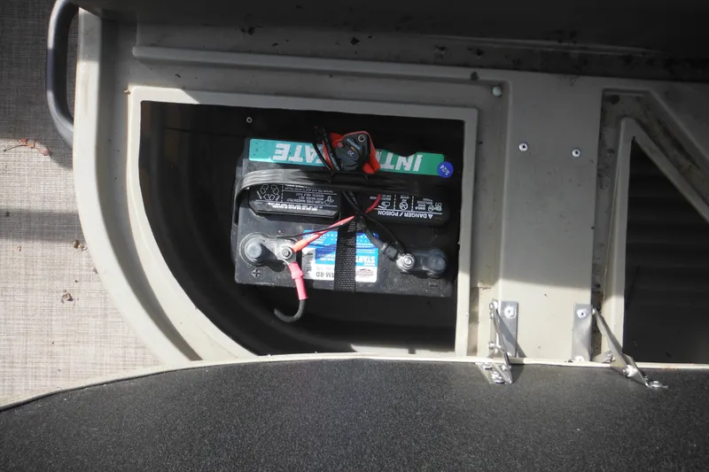 Slide: The Image of Storage compartment in 2024 Sun Tracker Bass Buggy 16 XL Select boat, containing a tarp and box. - 24