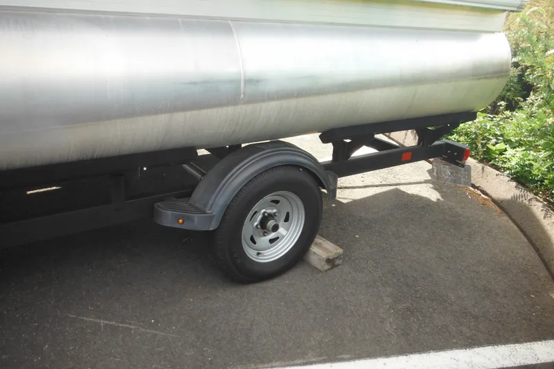 Slide: The Image of 2024 Sun Tracker Bass Buggy 16 XL Select pontoon boat rear view with motor and ladder. - 30