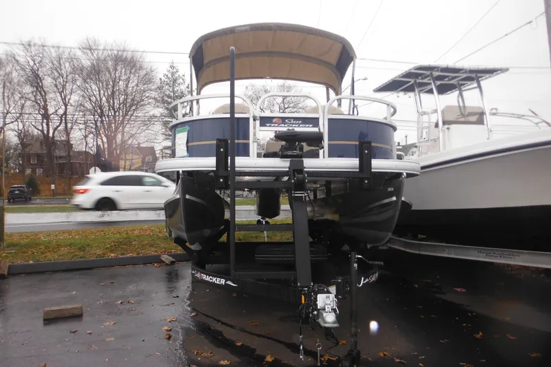 Slide: The Image of 2024 Sun Tracker Bass Buggy 16 XL Select pontoon boat on trailer, parked outdoors. - 34