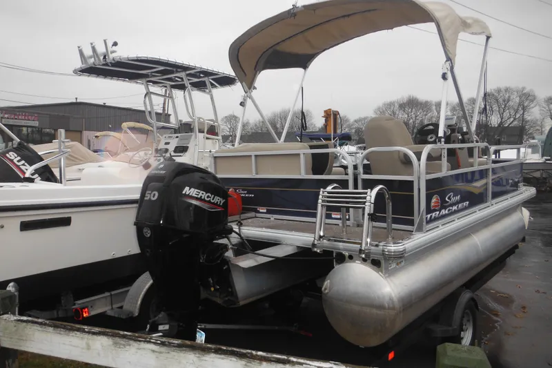 Slide: The Image of 2024 Sun Tracker Bass Buggy 16 XL Select pontoon boat with Mercury engine on trailer. - 35