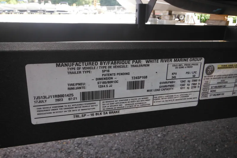 Slide: The Image of 2024 Sun Tracker Bass Buggy 16 XL Select trailer with steps and winch in parking lot. - 5