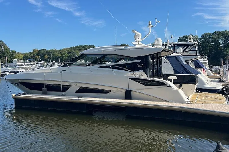 The Image of 2015 Sea Ray 470 Sundancer yacht docked at marina under clear blue sky. - 0