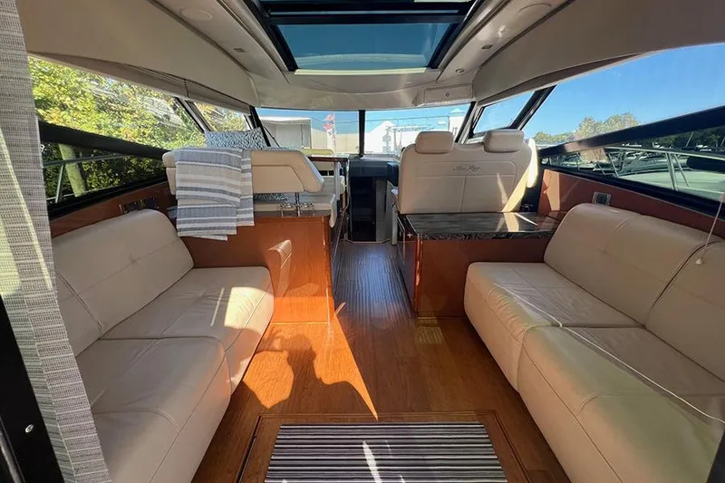 Slide: The Image of Interior of 2015 Sea Ray 470 Sundancer yacht with luxurious seating and wood flooring. - 10