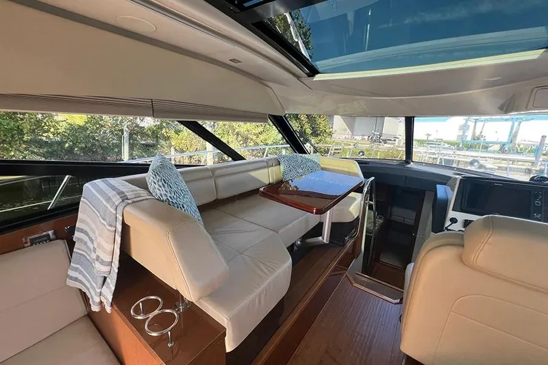 Slide: The Image of Interior of 2015 Sea Ray 470 Sundancer yacht with beige seating and skylight. - 12