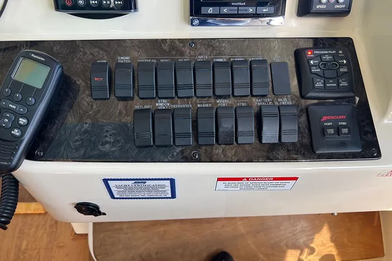 Slide: The Image of Control panel of a 2015 Sea Ray 470 Sundancer yacht with various switches and devices. - 14