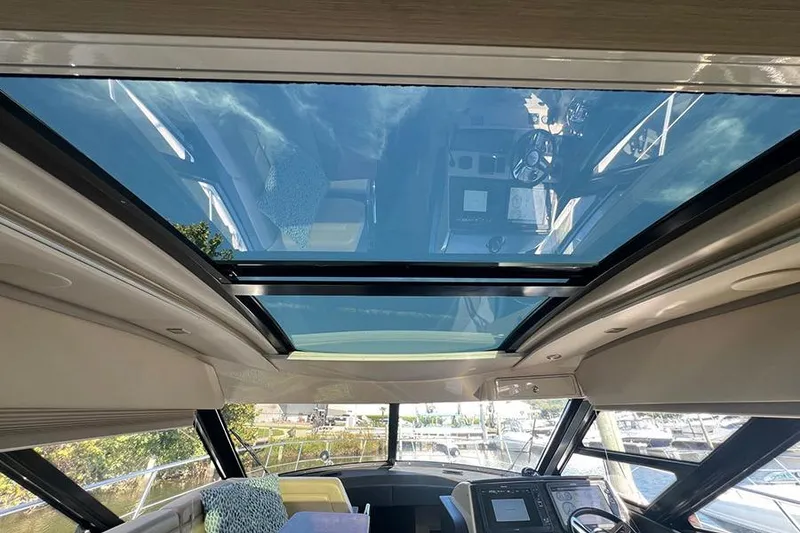 Slide: The Image of Interior view of 2015 Sea Ray 470 Sundancer with panoramic sunroof and modern helm. - 19