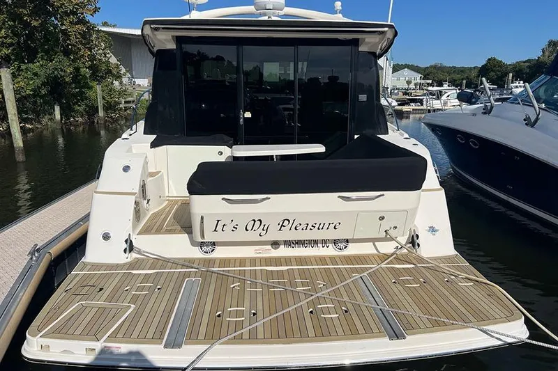 Slide: The Image of 2015 Sea Ray 470 Sundancer yacht docked, rear view with "It's My Pleasure" nameplate. - 2