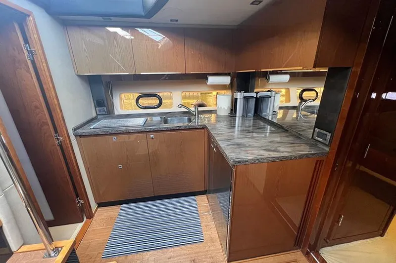 Slide: The Image of Luxurious kitchen interior of 2015 Sea Ray 470 Sundancer yacht with modern cabinetry and countertops. - 27