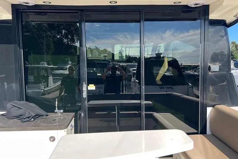 Slide: The Image of 2015 Sea Ray 470 Sundancer yacht with reflective glass doors and outdoor seating area. - 8