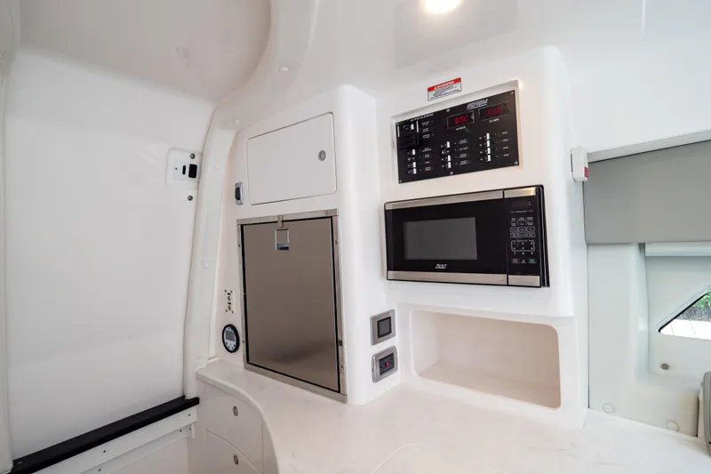 Slide: The Image of 2023 Intrepid 345 Valor interior with microwave, control panel, and storage. - 104