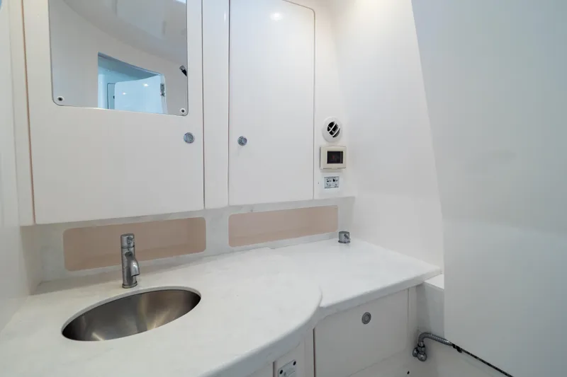 Slide: The Image of 2023 Intrepid 345 Valor boat bathroom with sleek white cabinetry and modern sink. - 107