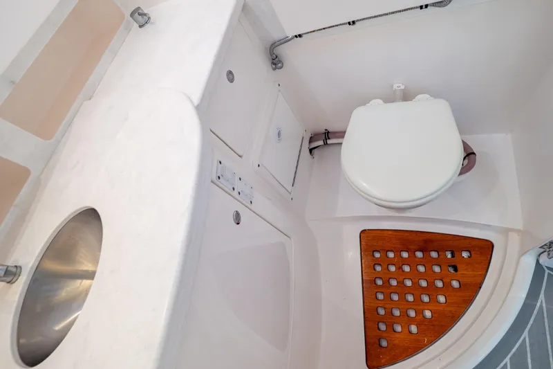 Slide: The Image of 2023 Intrepid 345 Valor boat bathroom with sink, toilet, and wooden floor panel. - 109