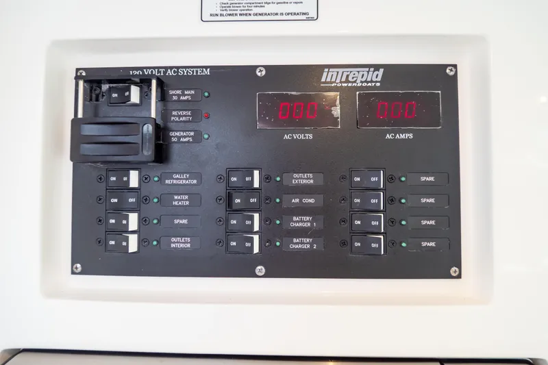 Slide: The Image of Control panel of 2023 Intrepid 345 Valor boat, showing AC system switches and indicators. - 116