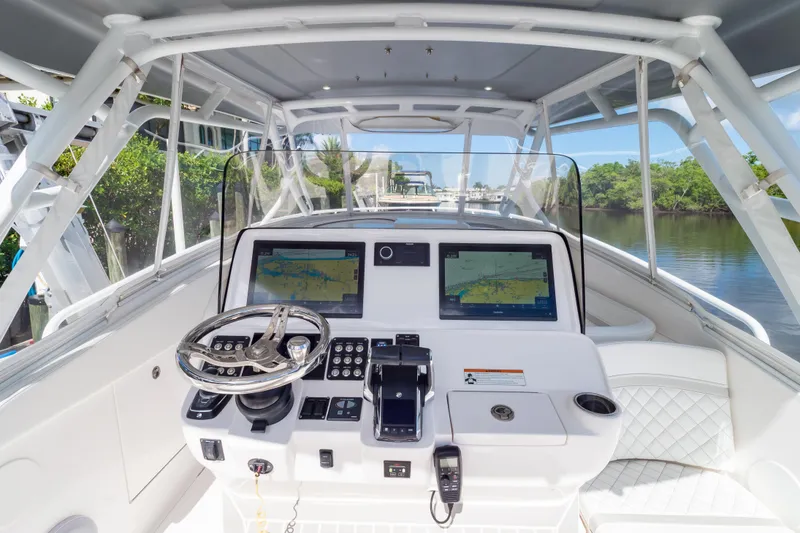 Slide: The Image of 2023 Intrepid 345 Valor boat cockpit with dual navigation screens and modern controls. - 2