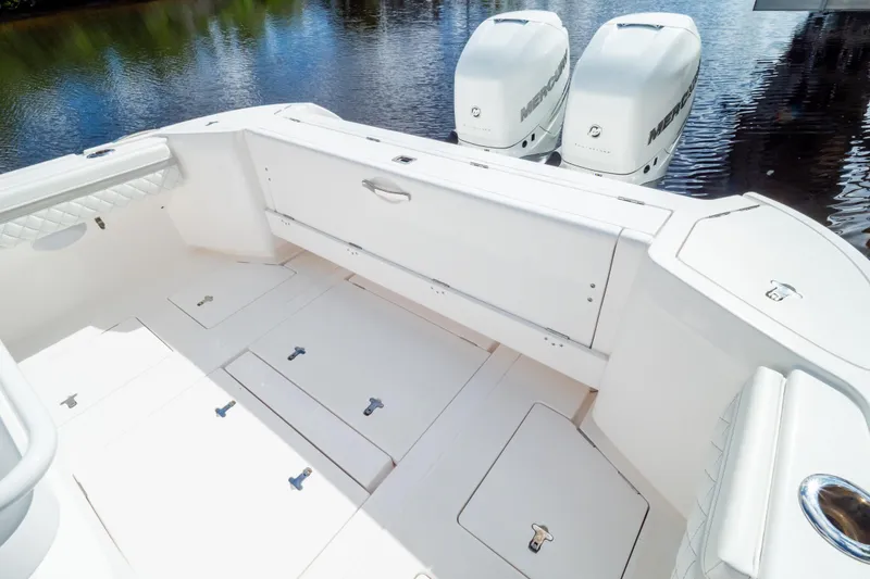 Slide: The Image of 2023 Intrepid 345 Valor boat deck with storage compartments and twin Mercury engines. - 23