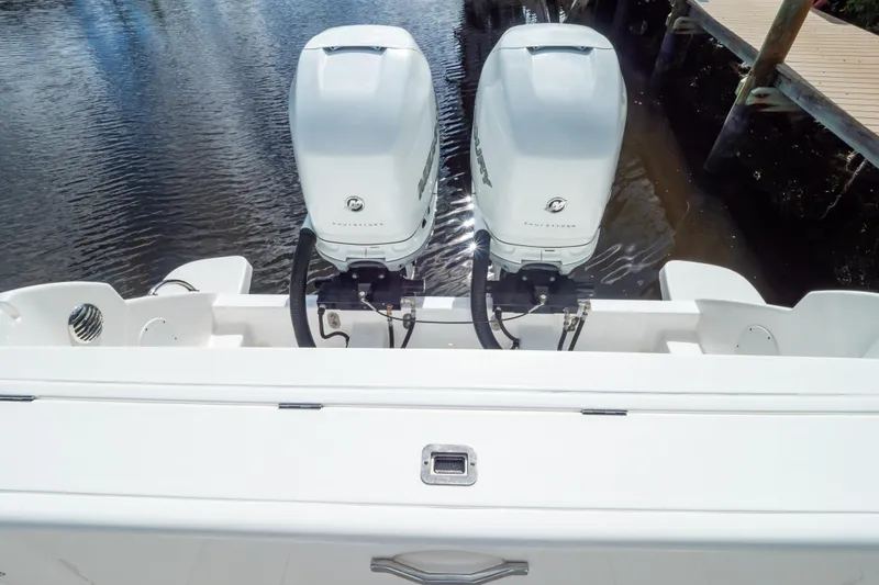Slide: The Image of 2023 Intrepid 345 Valor boat with dual outboard engines on calm water. - 24