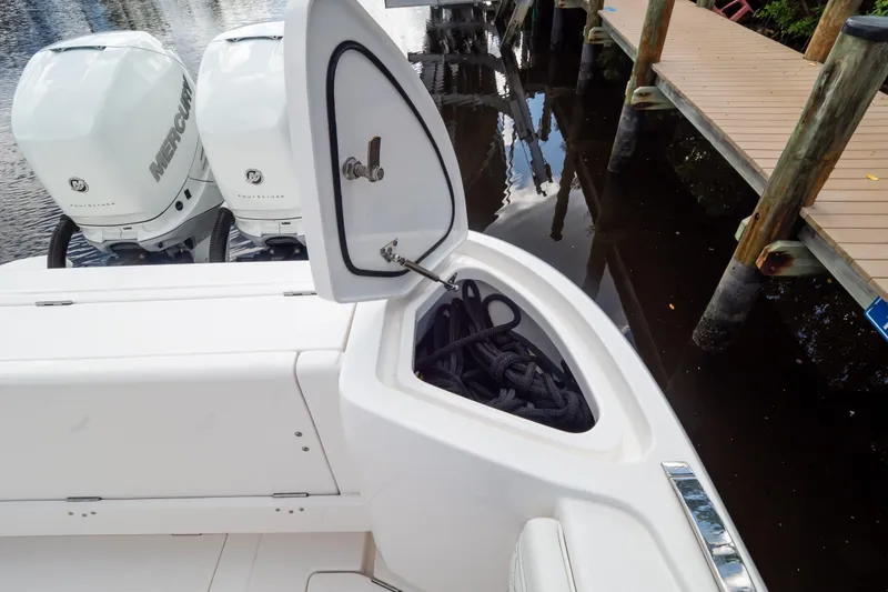 Slide: The Image of 2023 Intrepid 345 Valor boat with open storage compartment and twin Mercury engines. - 28