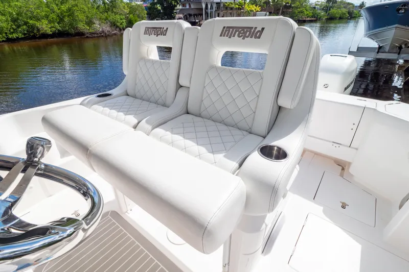 Slide: The Image of Luxurious seating on 2023 Intrepid 345 Valor boat, featuring elegant white upholstery and cup holders. - 3