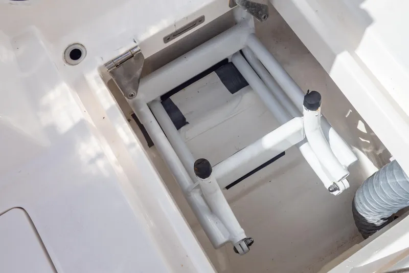 Slide: The Image of 2023 Intrepid 345 Valor boat compartment with folded ladder and metal hinges. - 38