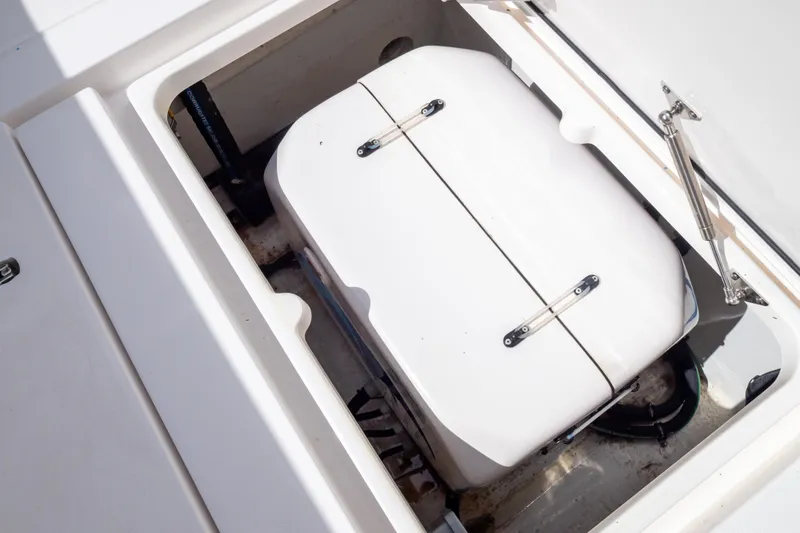 Slide: The Image of Storage compartment on 2023 Intrepid 345 Valor boat, featuring a white hatch and hydraulic support. - 45