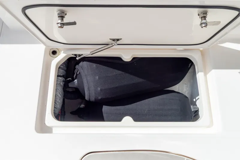 Slide: The Image of Open storage compartment on 2023 Intrepid 345 Valor boat, containing black fenders. - 47