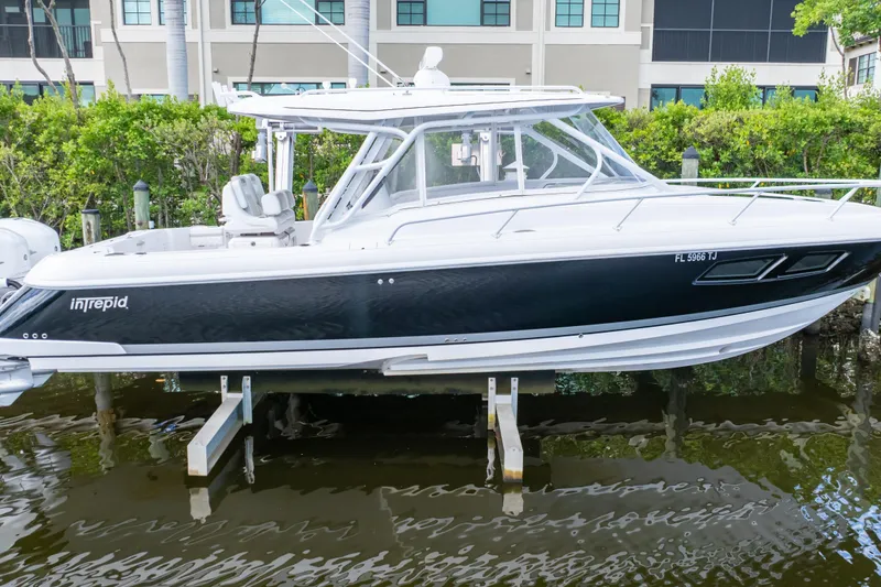 Slide: The Image of 2023 Intrepid 345 Valor boat docked, sleek design, black and white exterior. - 50