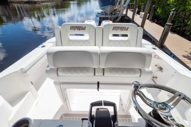 Slide: The Image of 2023 Intrepid 345 Valor boat interior with white seating and steering wheel. - 56