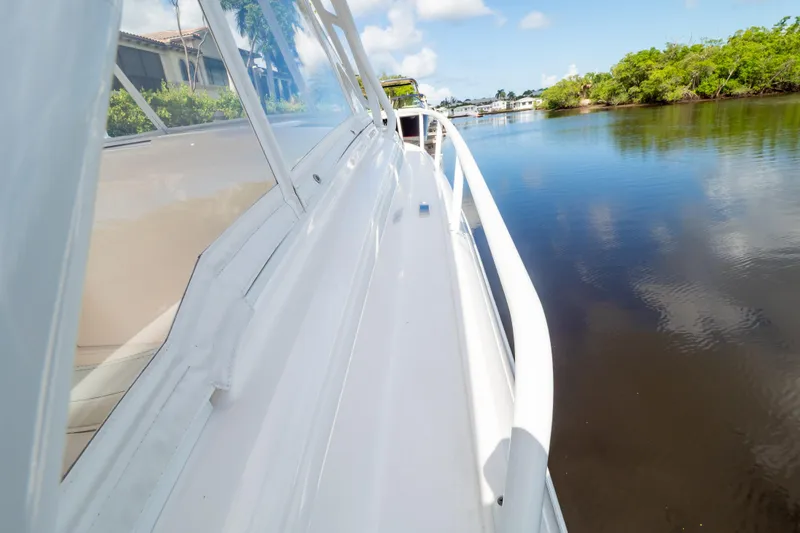 Slide: The Image of 2023 Intrepid 345 Valor boat cruising on a calm river under a clear sky. - 65
