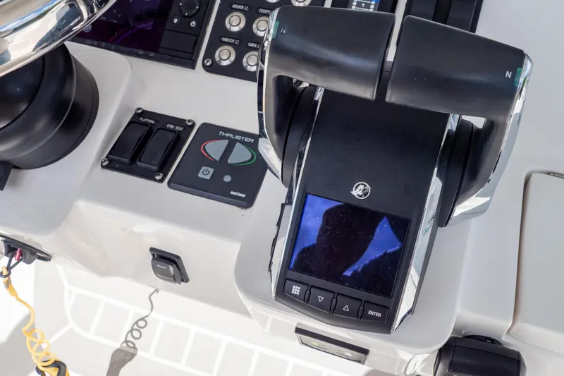 Slide: The Image of Control panel of 2023 Intrepid 345 Valor boat with throttle and navigation controls. - 76