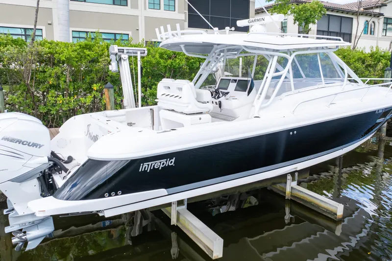 Slide: The Image of 2023 Intrepid 345 Valor boat with Mercury engines docked near waterfront homes. - 8