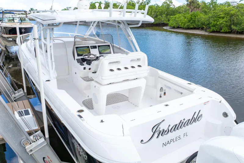 Slide: The Image of 2023 Intrepid 345 Valor boat docked in Naples, FL, featuring sleek design and modern controls. - 88