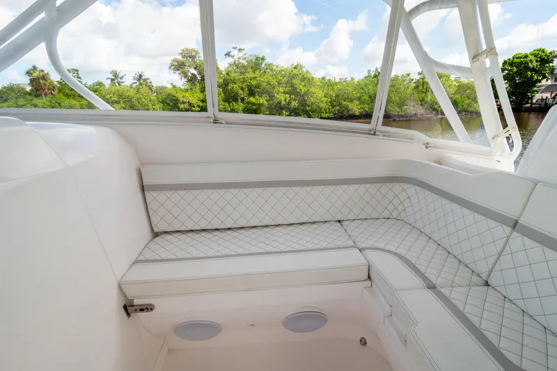 Slide: The Image of 2023 Intrepid 345 Valor boat interior with white cushioned seating and scenic water view. - 90