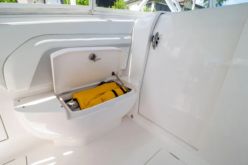Slide: The Image of 2023 Intrepid 345 Valor boat storage compartment with yellow life jacket inside. - 94