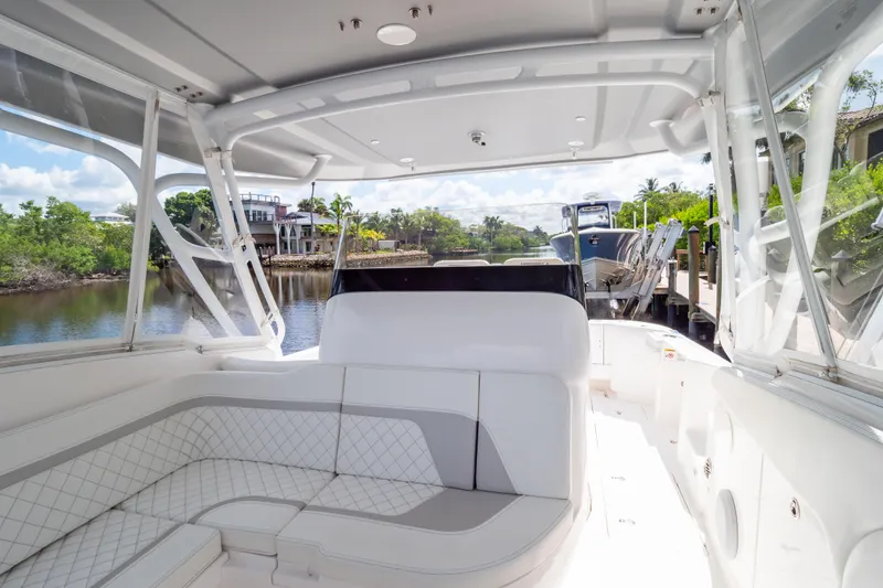 Slide: The Image of 2023 Intrepid 345 Valor boat interior with white seating and waterfront view. - 97