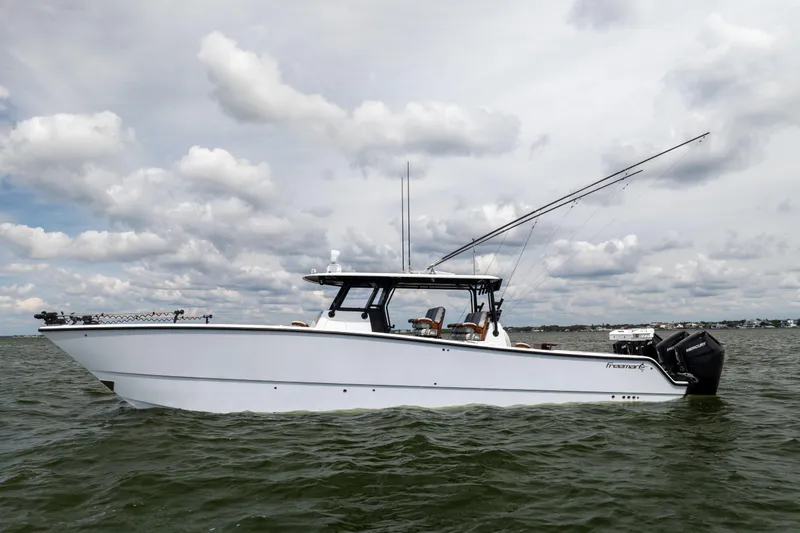 Slide: The Image of 2025 Freeman 42 LR boat on water under cloudy sky. - 2