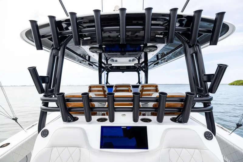 Slide: The Image of 2025 Freeman 42 LR boat interior with rod holders and seating, on calm water. - 37