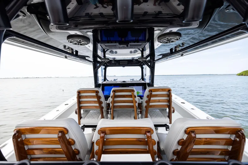 Slide: The Image of 2025 Freeman 42 LR boat interior with wooden seats, overlooking calm waters. - 38