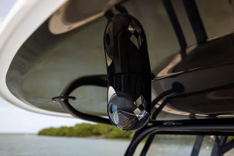 Slide: The Image of Close-up of a 2025 Freeman 42 LR boat camera under a canopy, with water and trees in the background. - 77