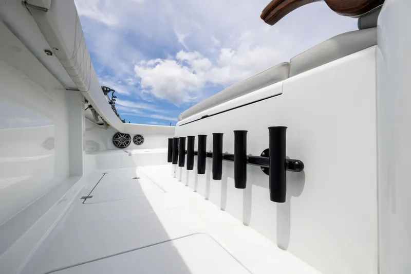 Slide: The Image of Sleek interior of 2025 Freeman 42 LR boat with rod holders and speakers under blue sky. - 79