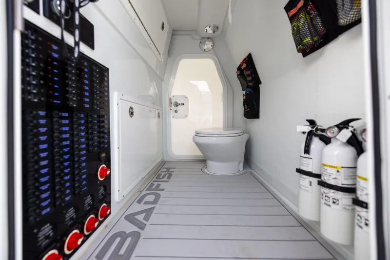 Slide: The Image of Interior of 2025 Freeman 42 LR boat with toilet, control panel, and fire extinguishers. - 82
