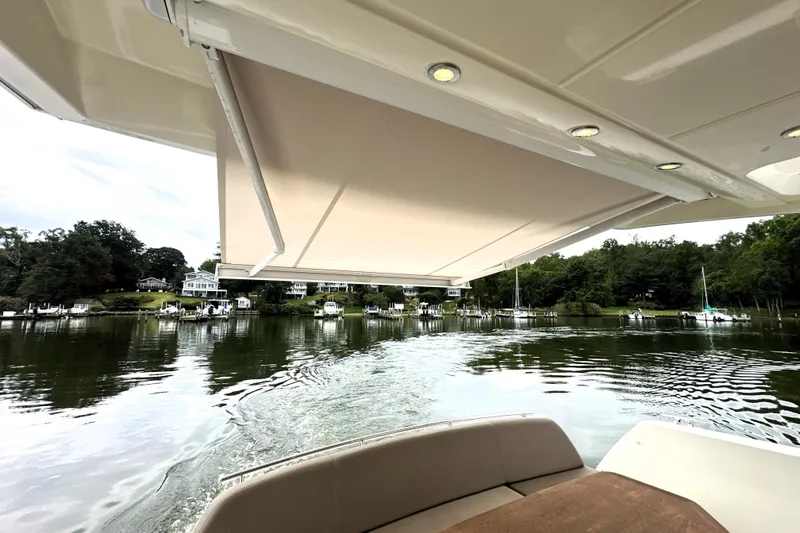 Slide: The Image of Prestige 450 yacht, 2014 model, cruising on a serene lake with scenic shoreline views. - 18