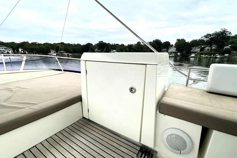 Slide: The Image of 2014 Prestige 450 yacht deck with seating, overlooking serene waterfront homes. - 24