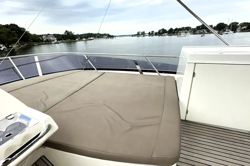 Slide: The Image of Luxurious 2014 Prestige 450 yacht deck with sunbed, overlooking serene waterfront scenery. - 26