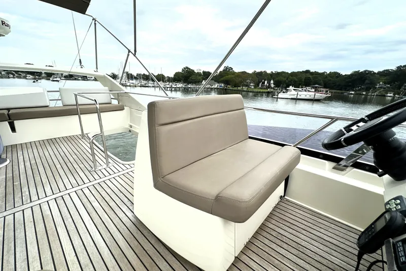 Slide: The Image of Luxurious 2014 Prestige 450 yacht deck with seating, overlooking serene marina. - 27
