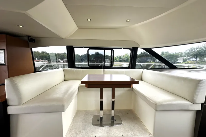 Slide: The Image of Luxurious interior of 2014 Prestige 450 yacht with white seating and wooden table. - 39