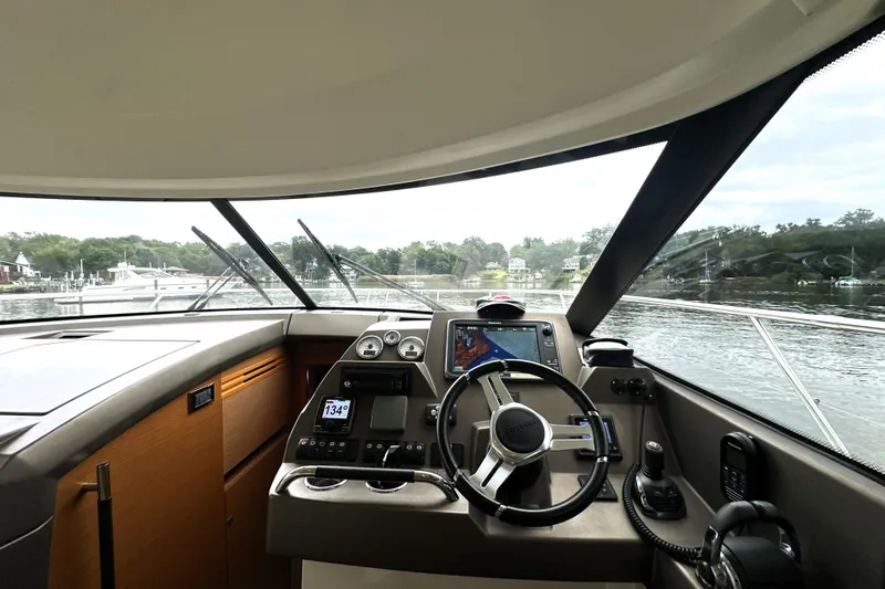 Slide: The Image of Interior view of 2014 Prestige 450 yacht cockpit with navigation controls and scenic waterway. - 46