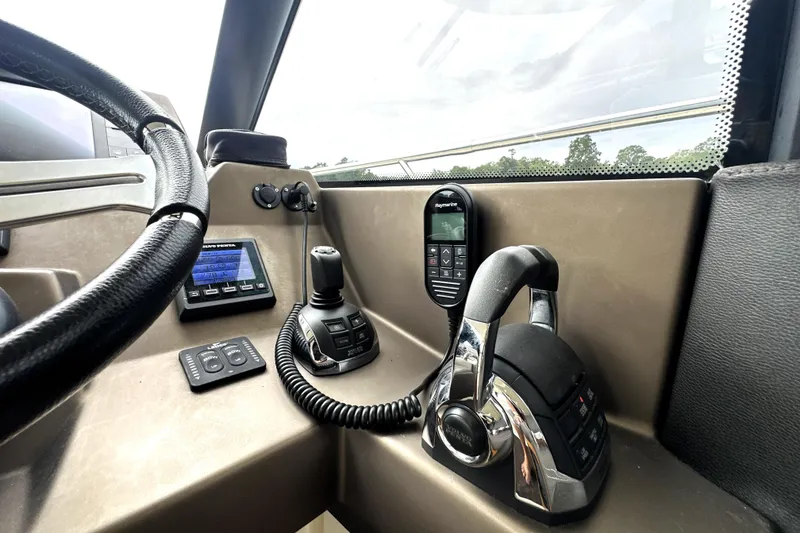 Slide: The Image of Control panel of a 2014 Prestige 450 yacht with steering wheel and navigation equipment. - 47