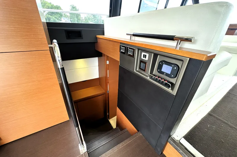 Slide: The Image of Interior view of 2014 Prestige 450 yacht, featuring modern control panel and wooden staircase. - 59