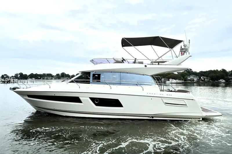 Slide: The Image of 2014 Prestige 450 yacht cruising on calm waters, showcasing sleek design and luxury features. - 9