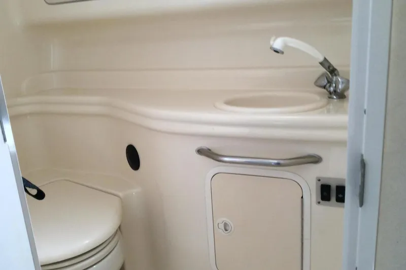 Slide: The Image of 2003 Sea Ray 320 Sundancer bathroom with sink, toilet, and storage cabinet. - 10